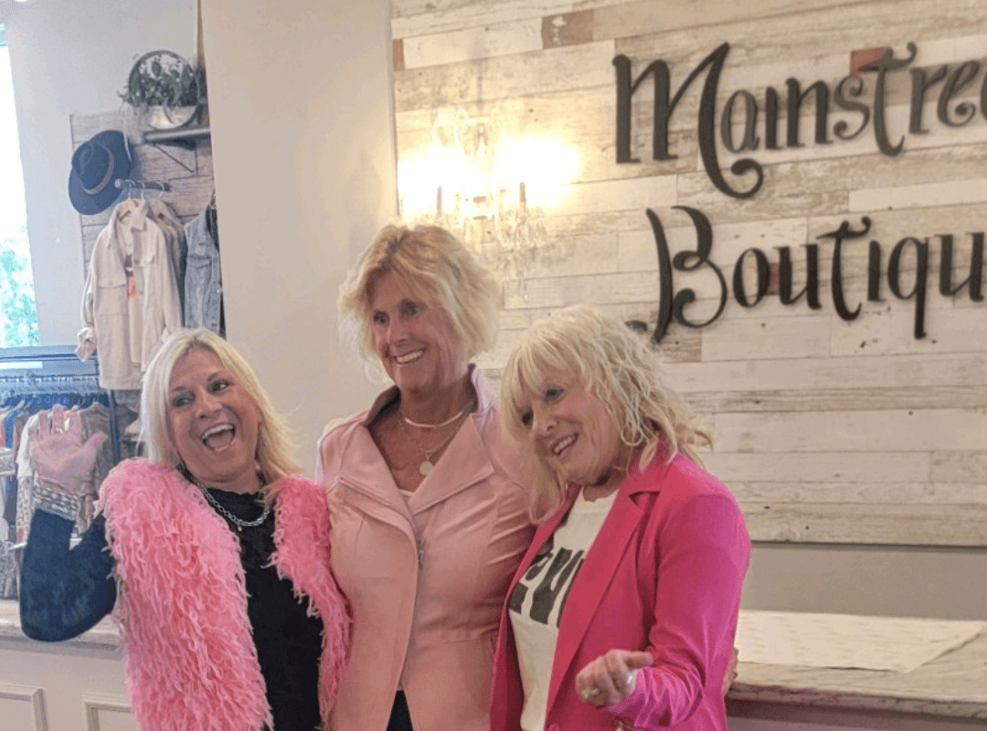 ladies posing by boutique sign